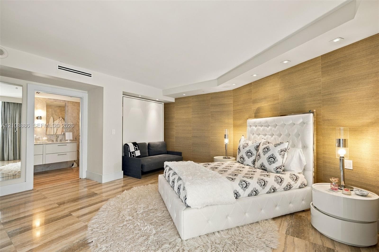 Textured wood-panel accent wall, recessed ceiling lighting, and polished stone flooring
