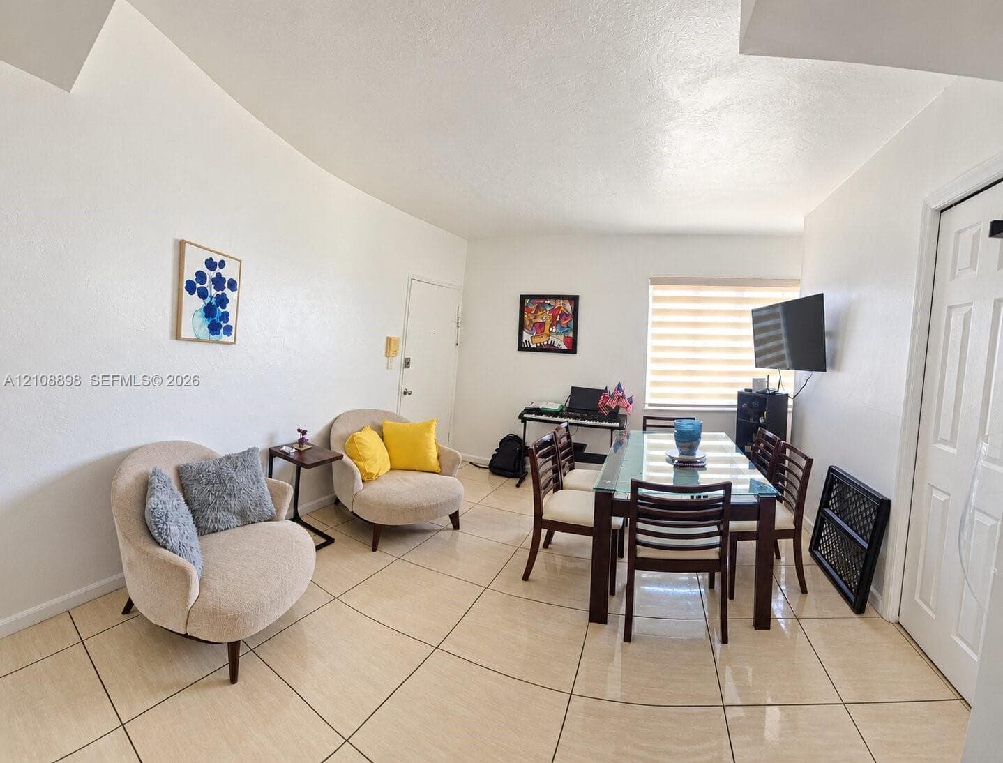 Large-format tile flooring, neutral wall palette, and window with horizontal blinds