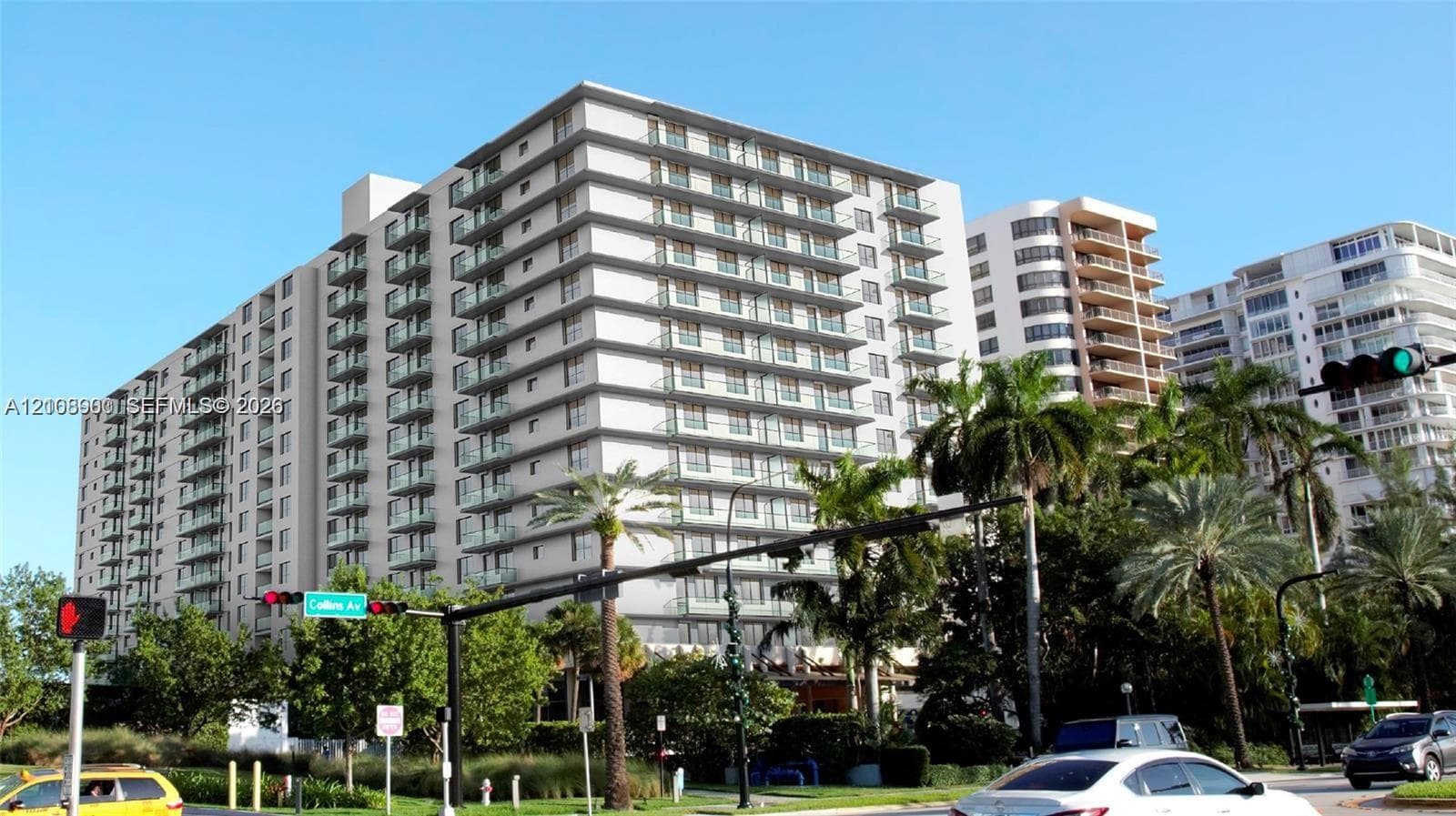 Mid-rise residential building featuring stacked balconies, concrete facade, and mature landscaping