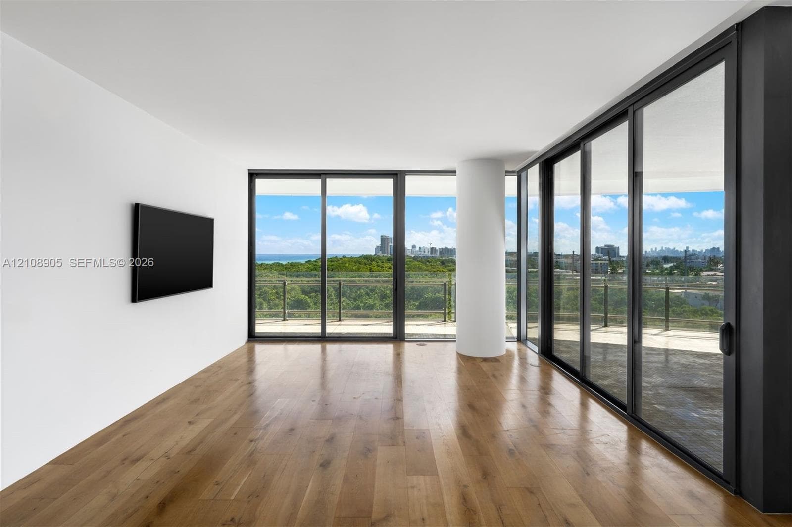 Floor-to-ceiling glass sliding doors, wood-finish flooring, structural column, and expansive outdoor terrace