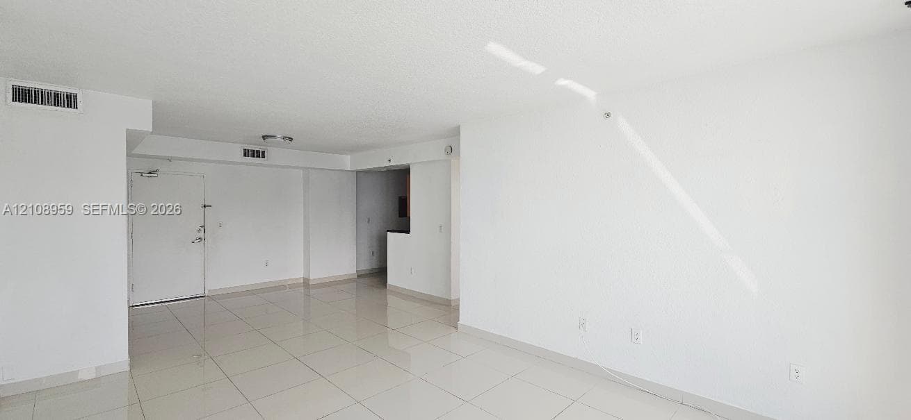 Open-concept interior featuring light-toned tile flooring, smooth wall finishes, and a neutral color palette