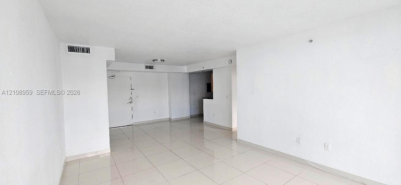 Open-concept interior featuring light-toned large-format tile flooring and neutral wall finishes