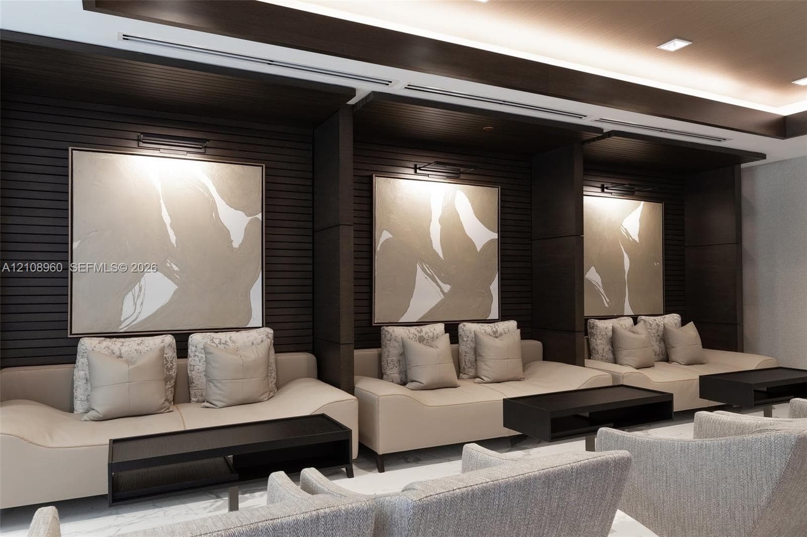 Custom dark wood-finish wall paneling, recessed architectural alcoves, integrated wall-mounted lighting, and recessed ceiling illumination