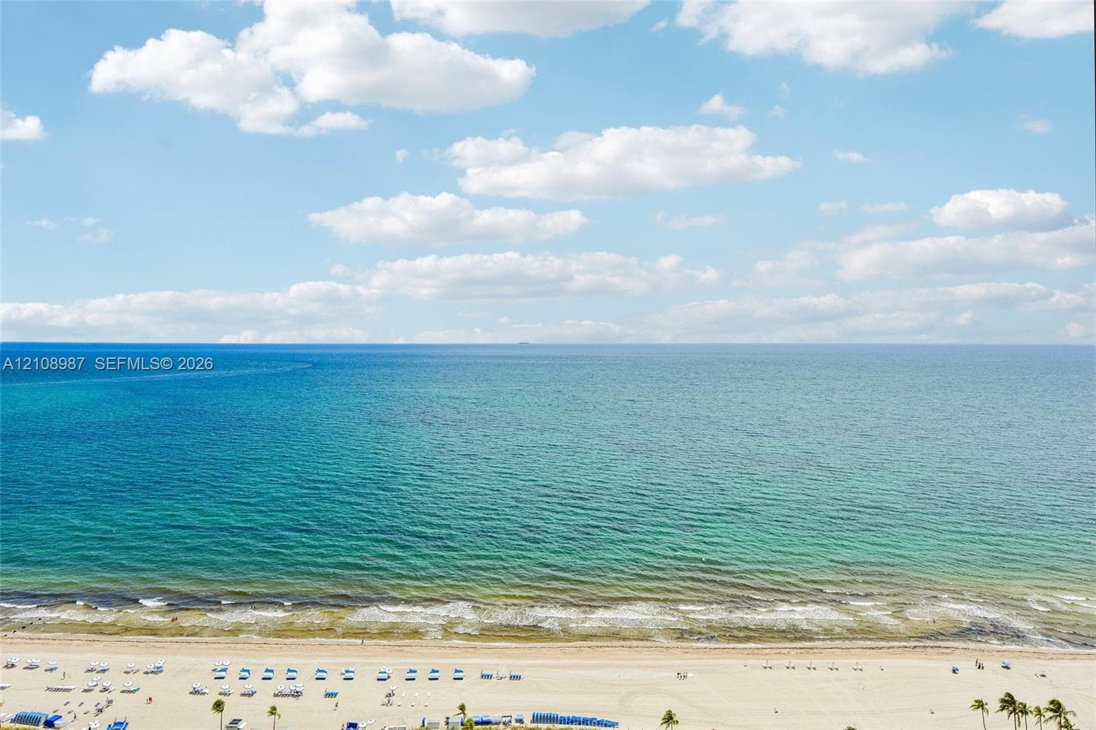 Direct oceanfront scenery featuring expansive blue water, surf, and a sandy beach