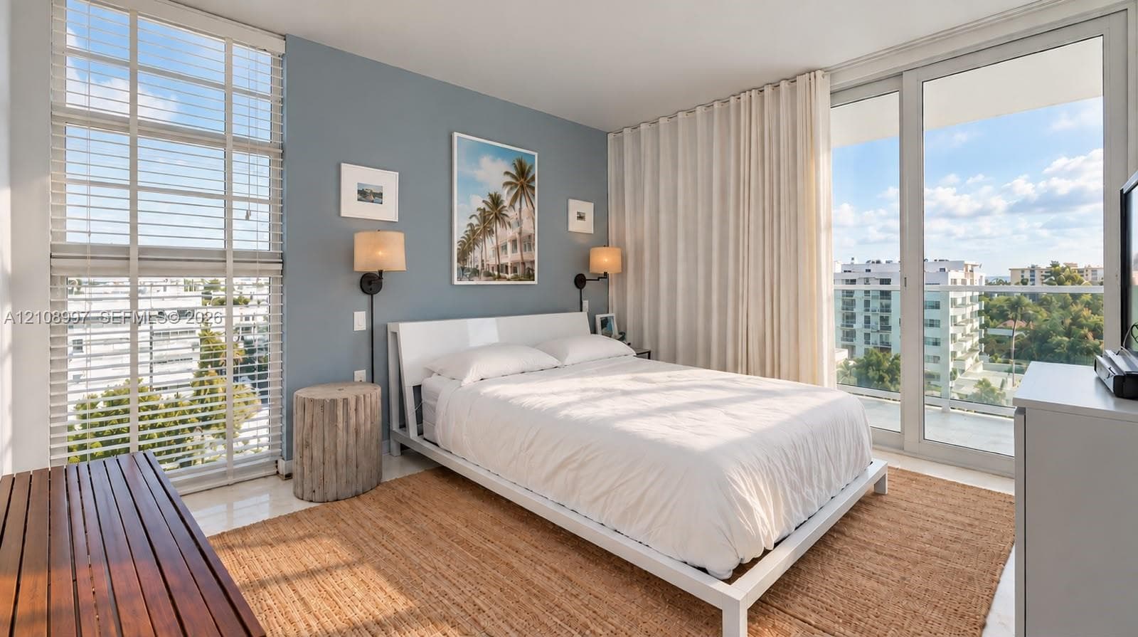 Floor-to-ceiling windows, polished neutral-toned flooring, wall-mounted sconce lighting, and glass sliding doors opening to a balcony
