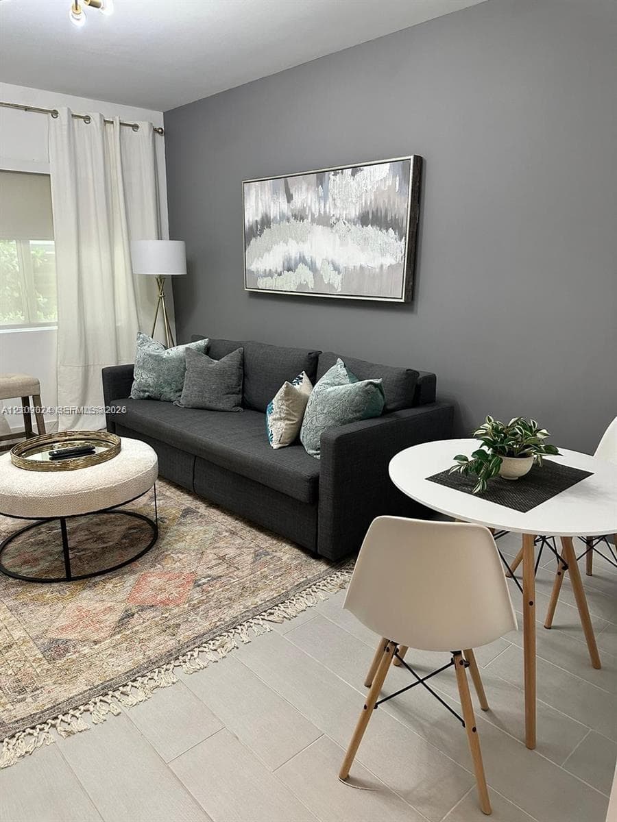 Neutral-toned walls, light-colored tile flooring, and window treatments with ceiling-mounted hardware