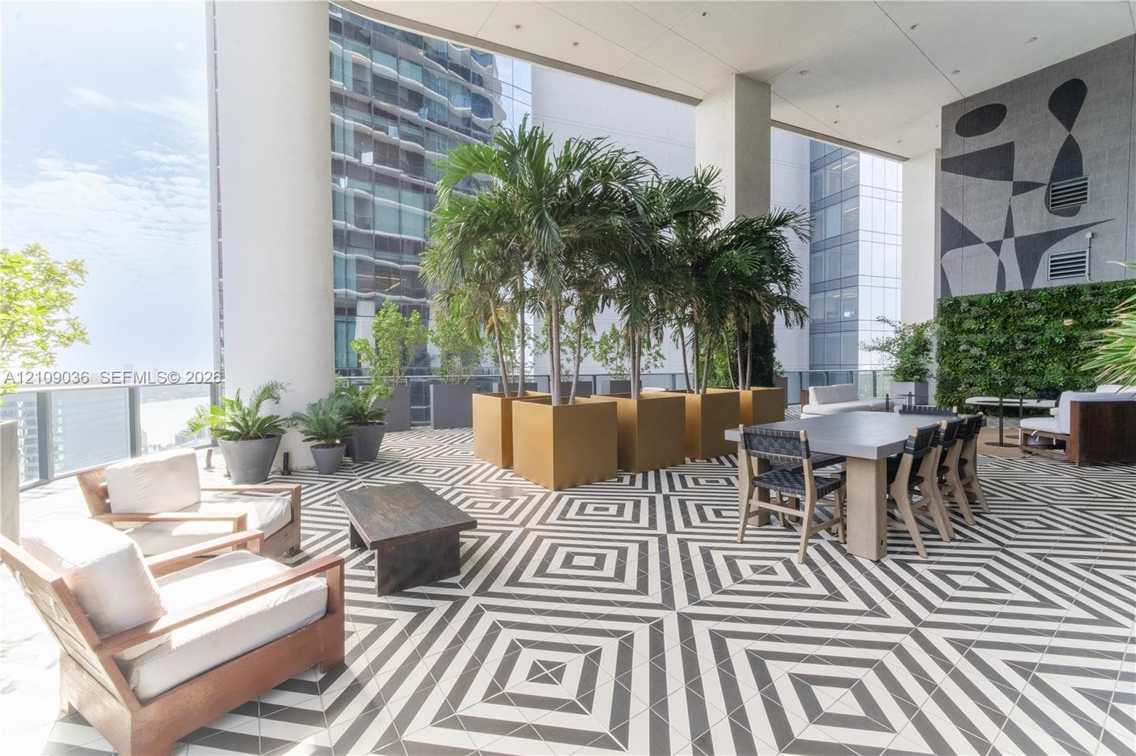 Covered outdoor terrace featuring geometric patterned floor tiling, integrated vertical greenery, and built-in structural columns