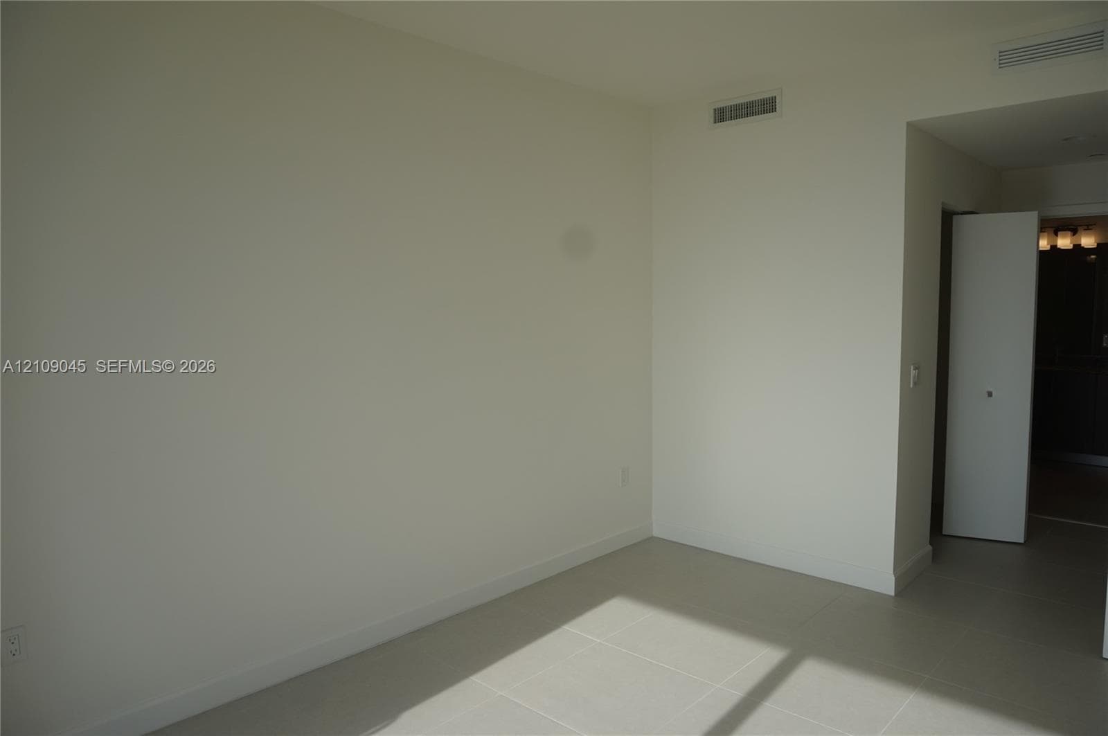 Neutral-toned interior space featuring light-colored tile flooring and white wall finishes