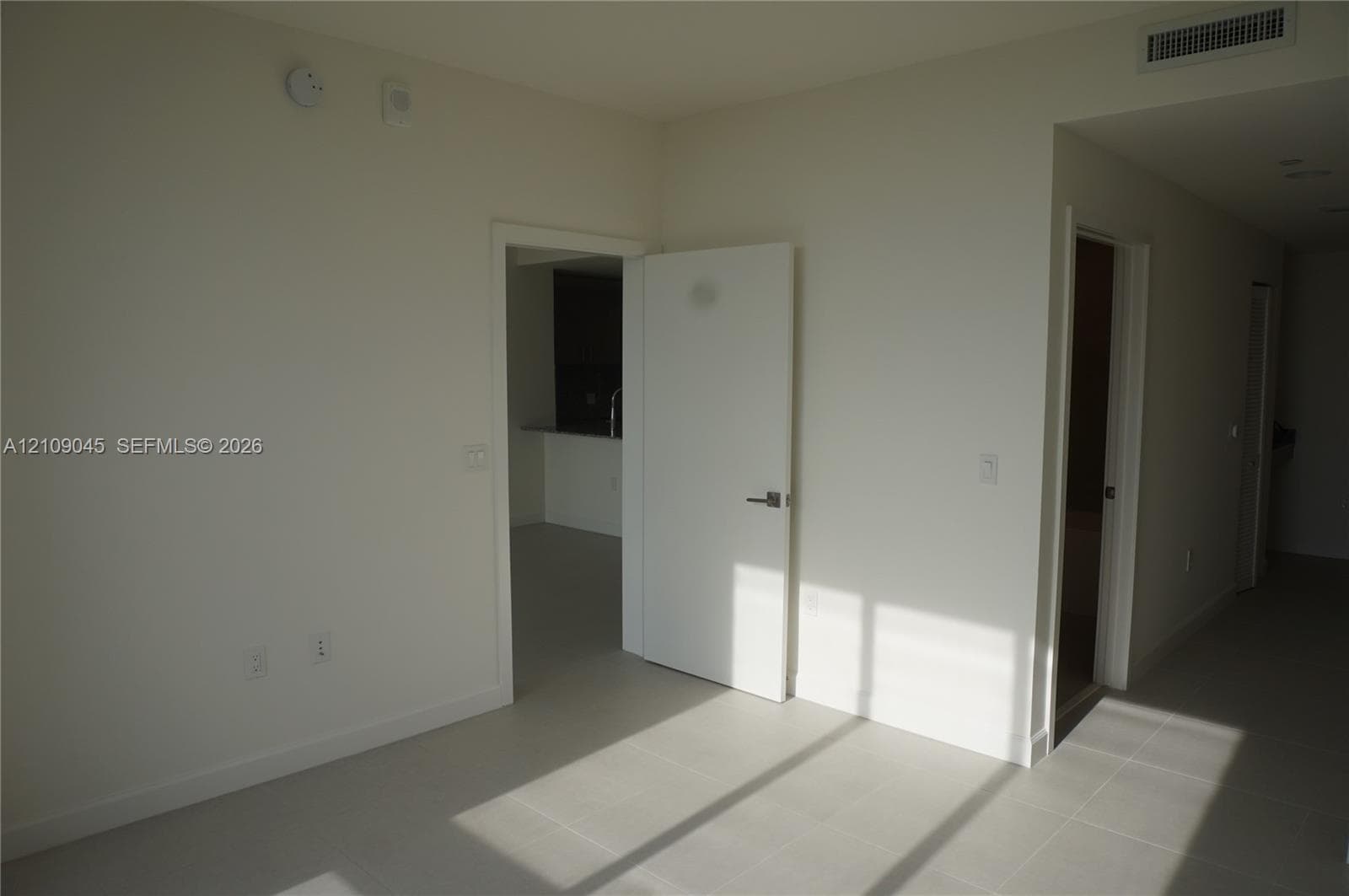 Neutral-toned tile flooring, solid-core interior doors with satin nickel hardware, and recessed ceiling HVAC registers