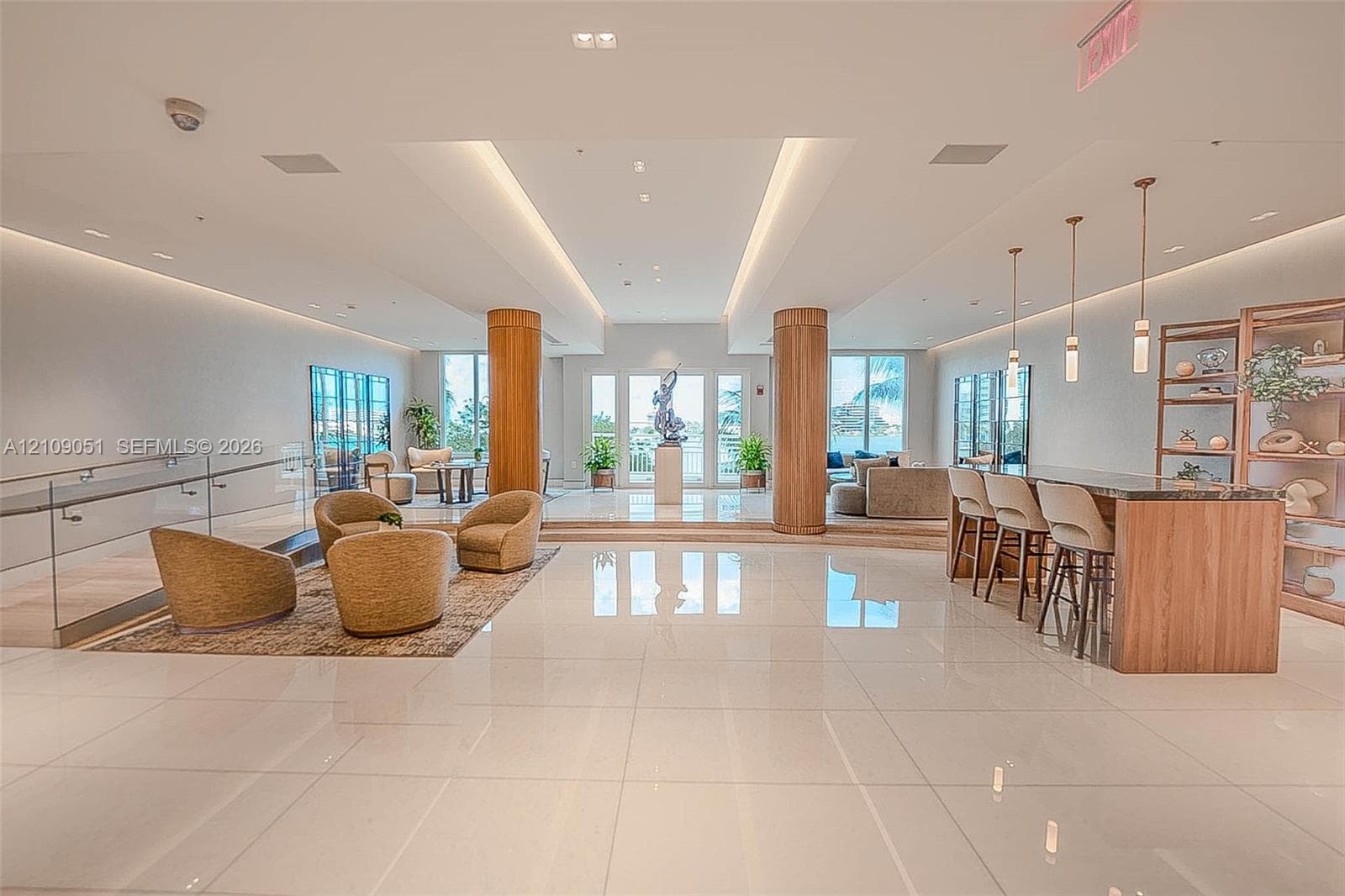 Open-concept interior featuring polished tile flooring, wood-clad structural columns, integrated cove lighting, and a built-in bar with matching cabinetry
