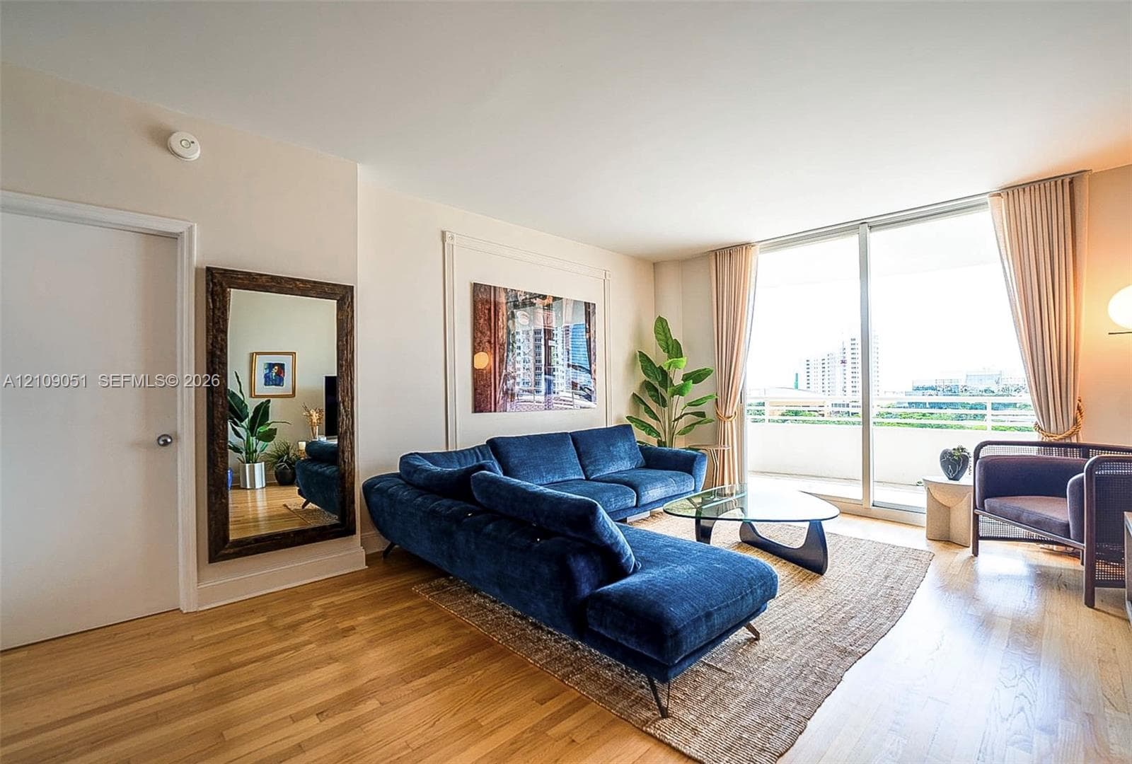 Interior space featuring wood-finish flooring, full-height windows, and architectural wall molding