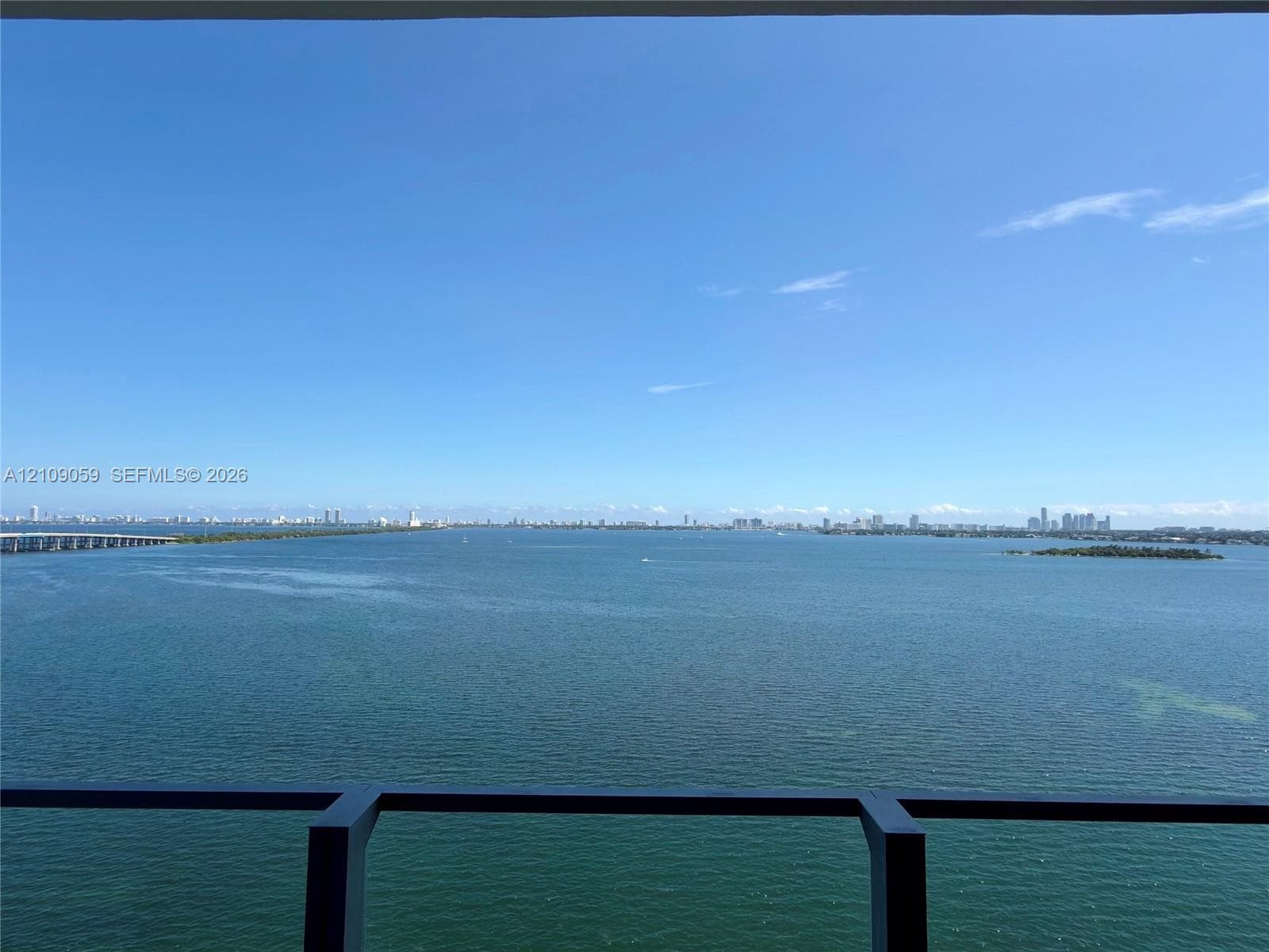Elevated balcony featuring a dark metal railing with expansive, unobstructed water scenery
