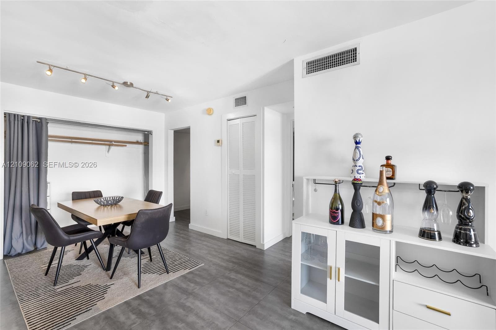 Neutral-tone wood-finish flooring, adjustable track lighting, and bi-fold closet doors