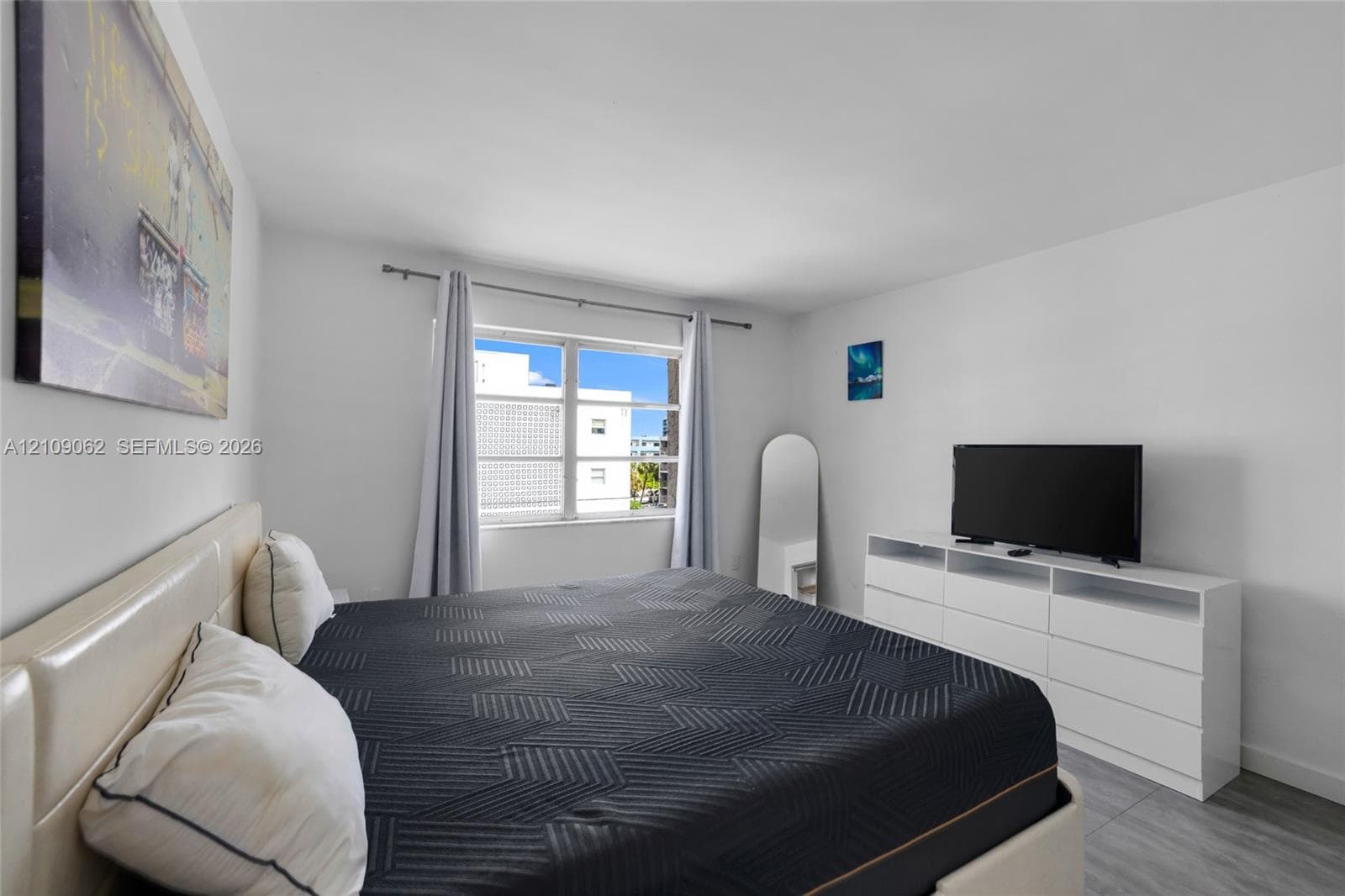 Room featuring neutral wall paint, horizontal slider window, and gray-toned flooring