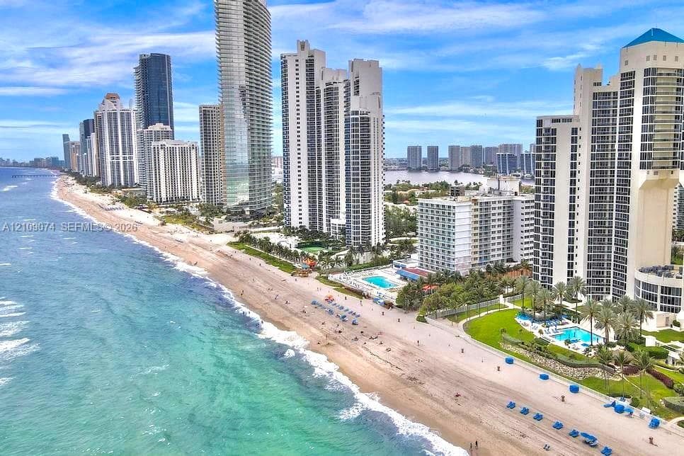 Oceanfront high-rise skyline featuring direct beach access, coastal shoreline, and private outdoor swimming pools