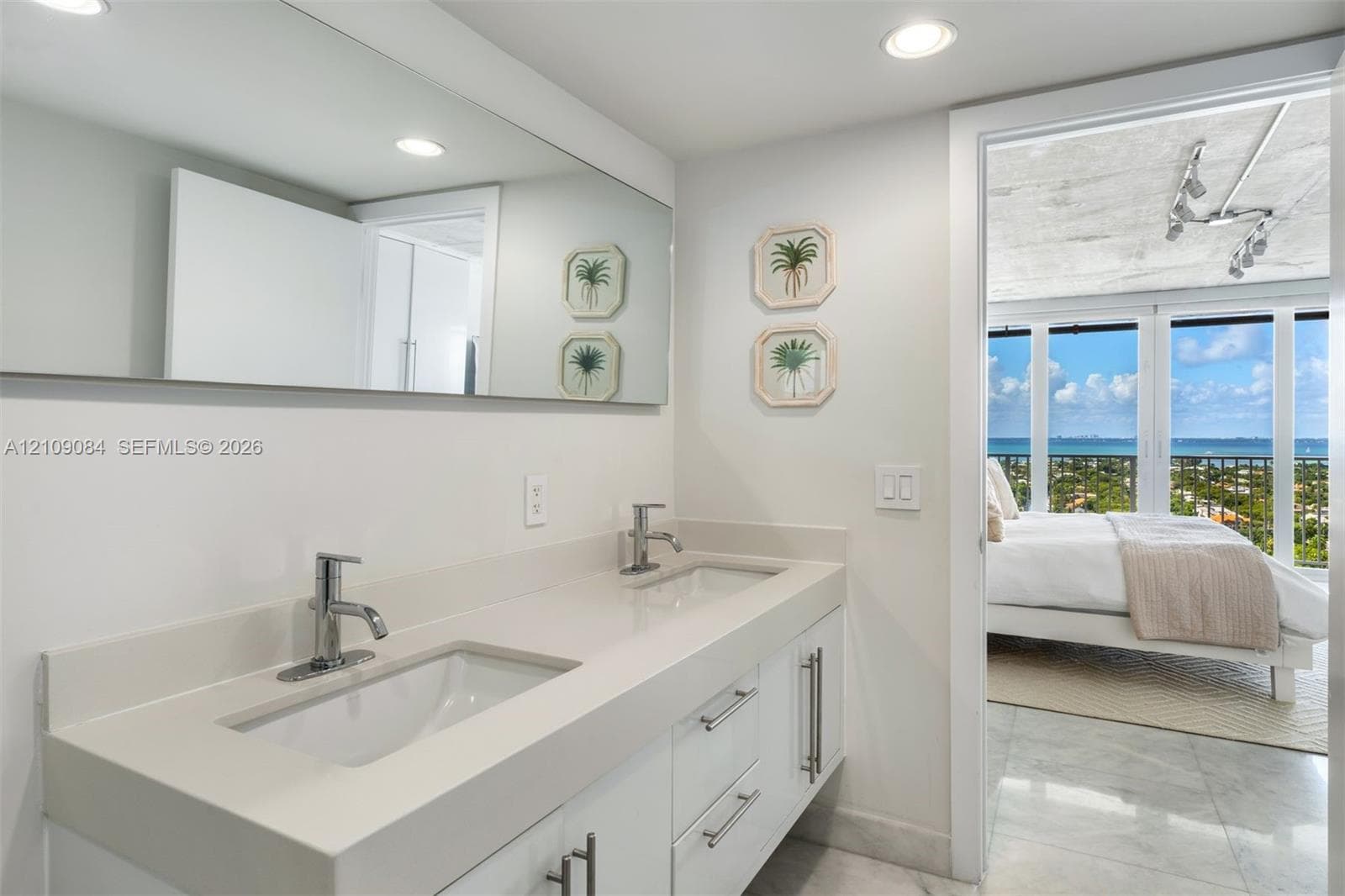Exposed concrete ceiling with industrial-style surface-mounted track lighting, polished stone flooring, and high-gloss cabinetry