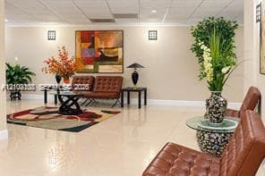 Spacious interior featuring neutral wall tones, large-format polished tile flooring, and wall-mounted geometric light fixtures
