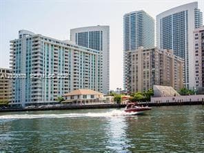 Waterfront high-rise residential architecture featuring floor-to-ceiling glass paneling, concrete balconies, and direct deep-water access