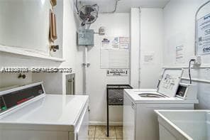 Laundry room featuring top-load washing machine, dryer, built-in utility sink, and wall-mounted ventilation fan