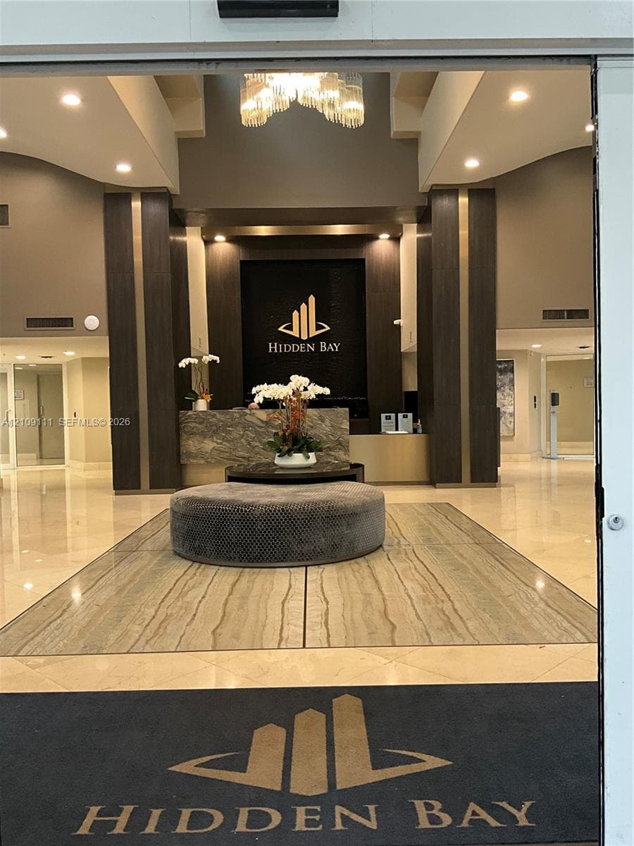 Lobby featuring polished stone flooring, recessed lighting, a stone-front reception desk, and decorative pendant lighting