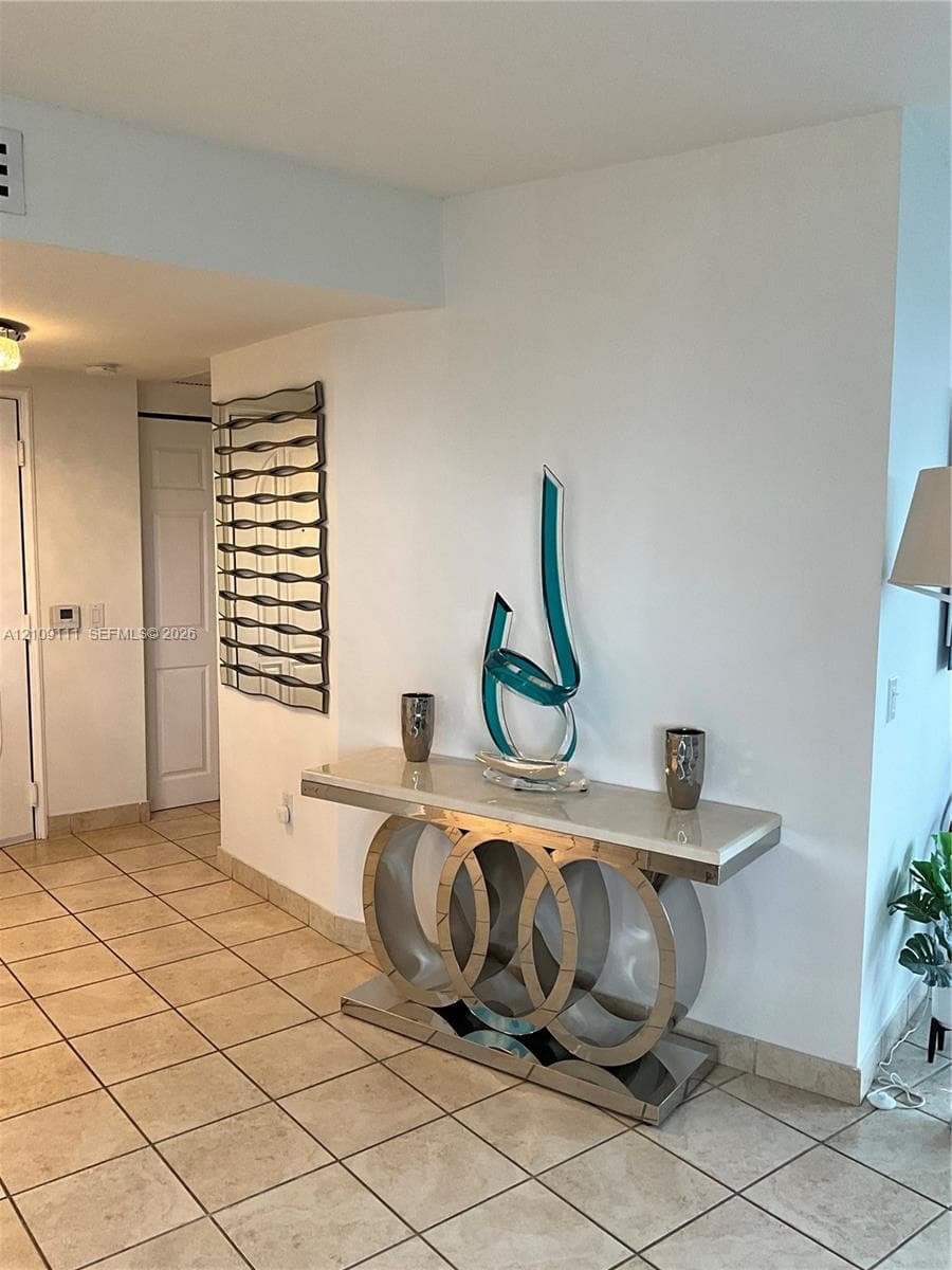 Neutral-toned tile flooring and wall-mounted decorative mirrored glass panel