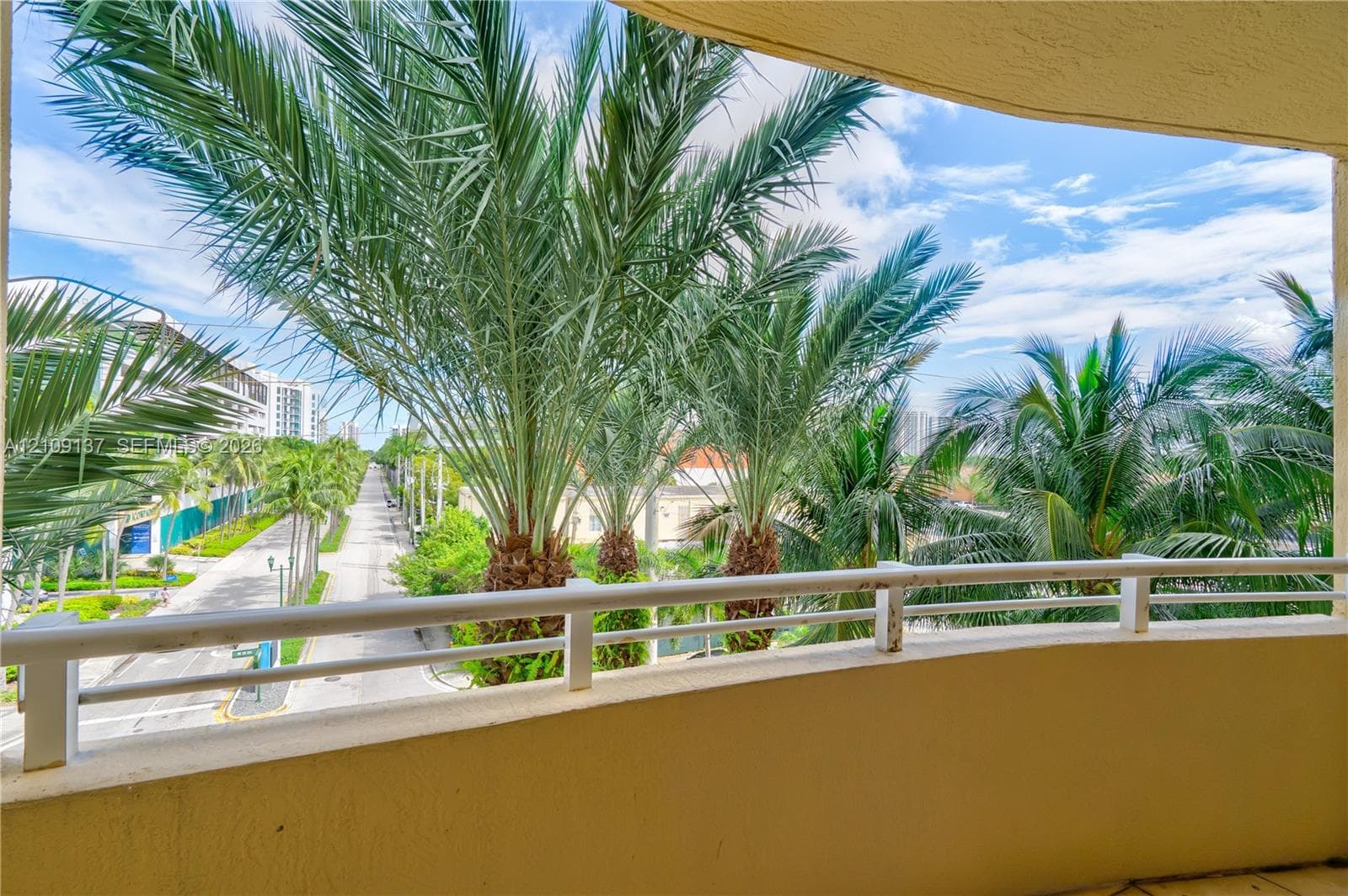 Covered balcony featuring a white metal railing and tile flooring
