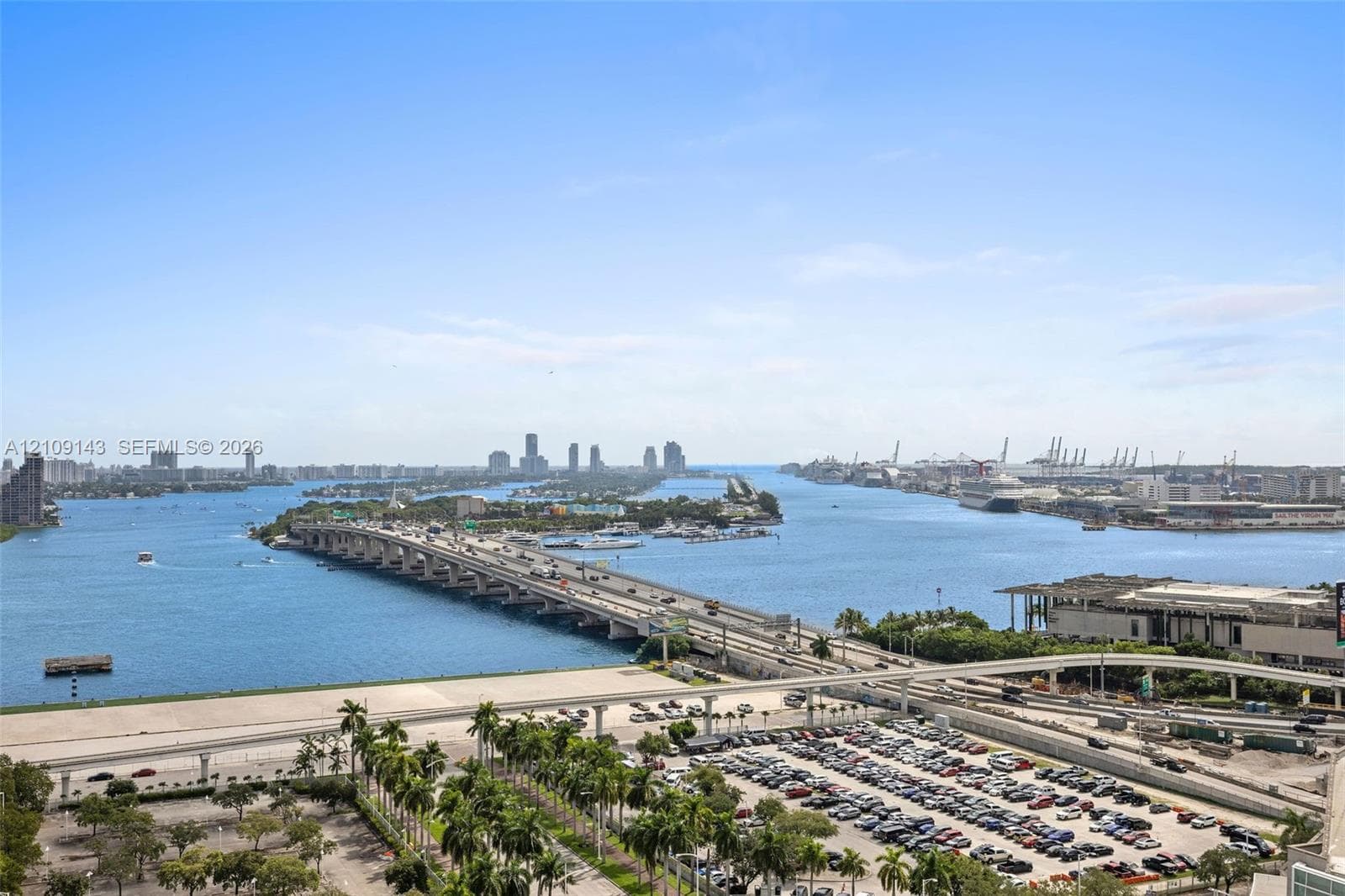 Elevated perspective featuring expansive water frontage, a multi-lane causeway, and a skyline backdrop