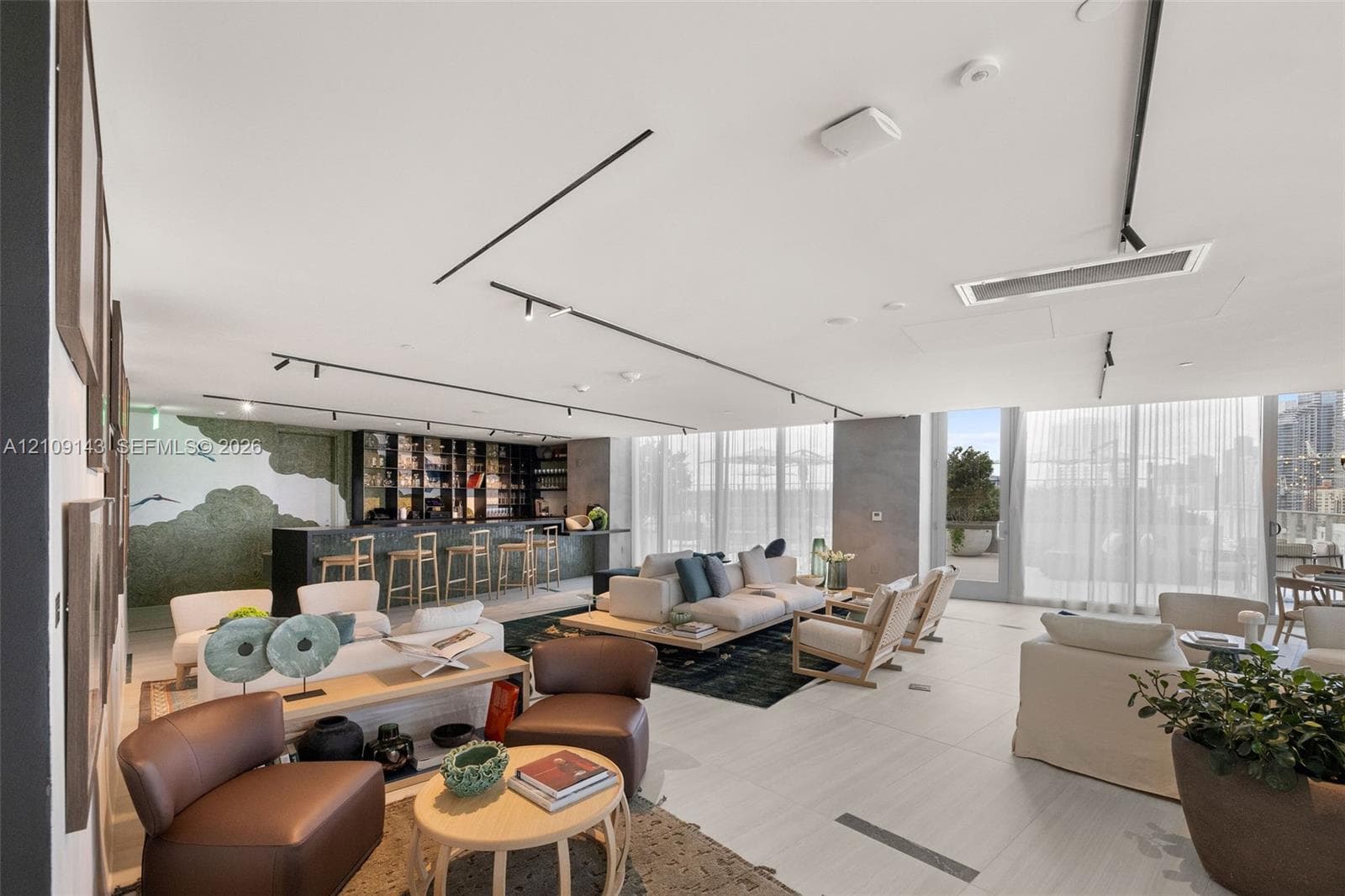 Large-format tile flooring, built-in wet bar with dark stone countertop, recessed track lighting system, and floor-to-ceiling glass windows