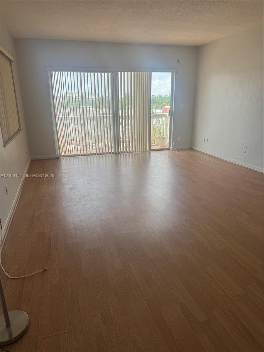 Open-concept room featuring light-toned wood-finish flooring and floor-to-ceiling sliding glass doors