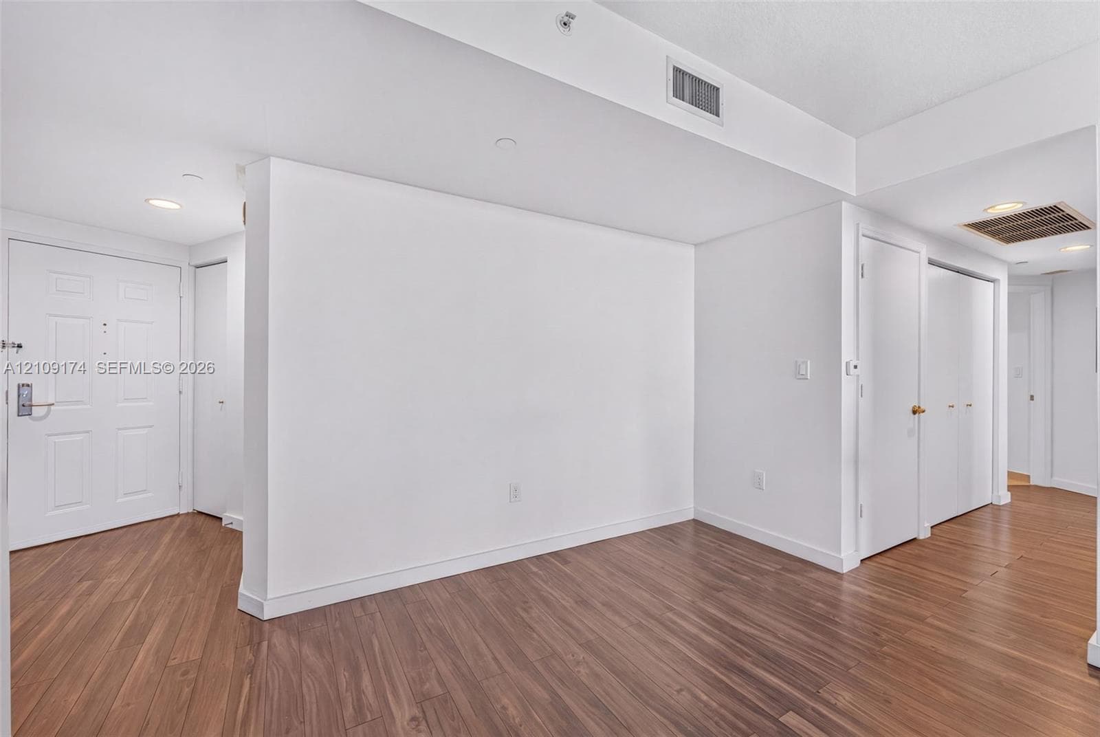 Open floor plan interior featuring wood-finish flooring, recessed lighting, and multiple closet storage areas