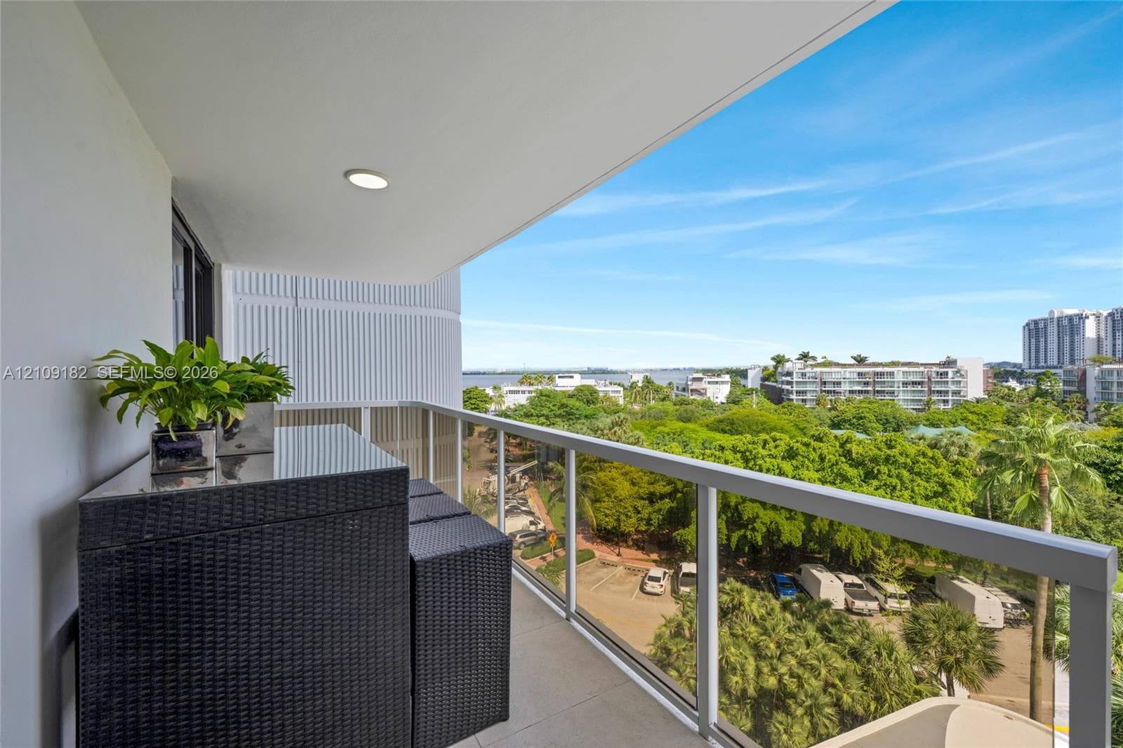 Covered balcony featuring tile flooring, recessed lighting, and a metal-framed glass railing