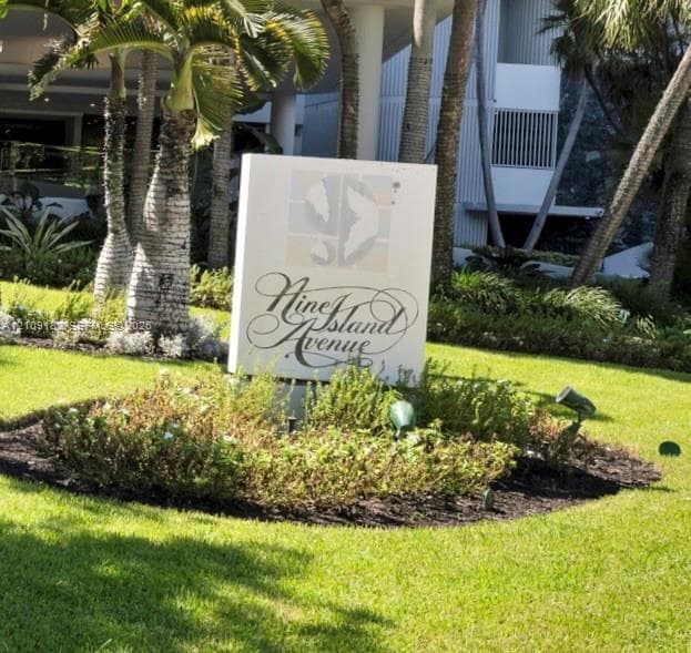 Monolithic property signage featuring mature palm trees, manicured landscaping, and accent landscape lighting