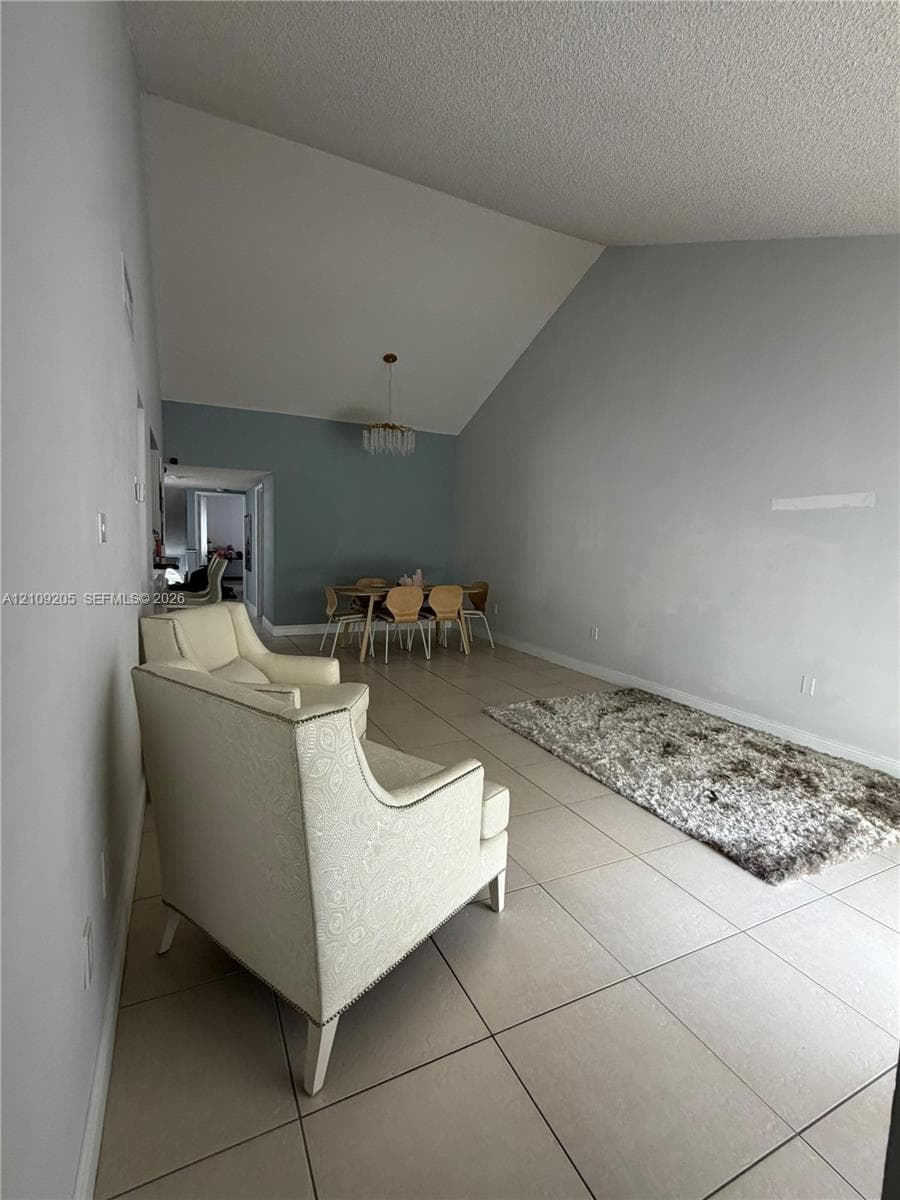 Vaulted ceilings, large-format tile flooring, and a decorative pendant light fixture