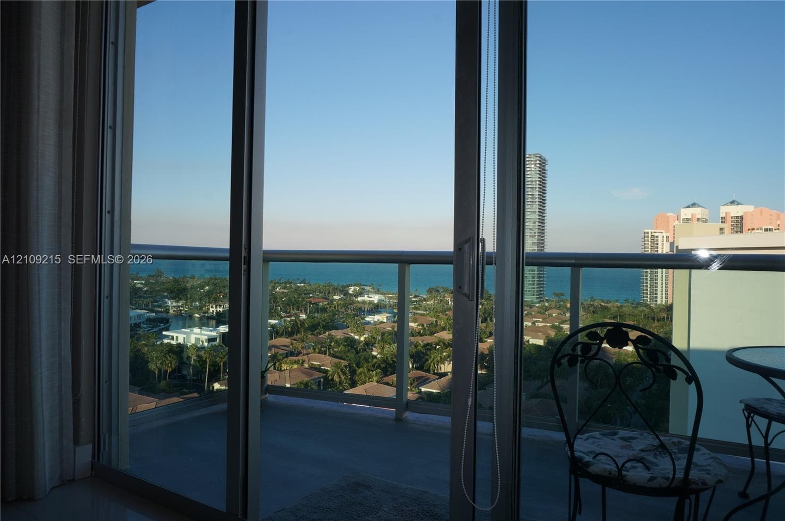 Floor-to-ceiling sliding glass door, private balcony, and metal railing
