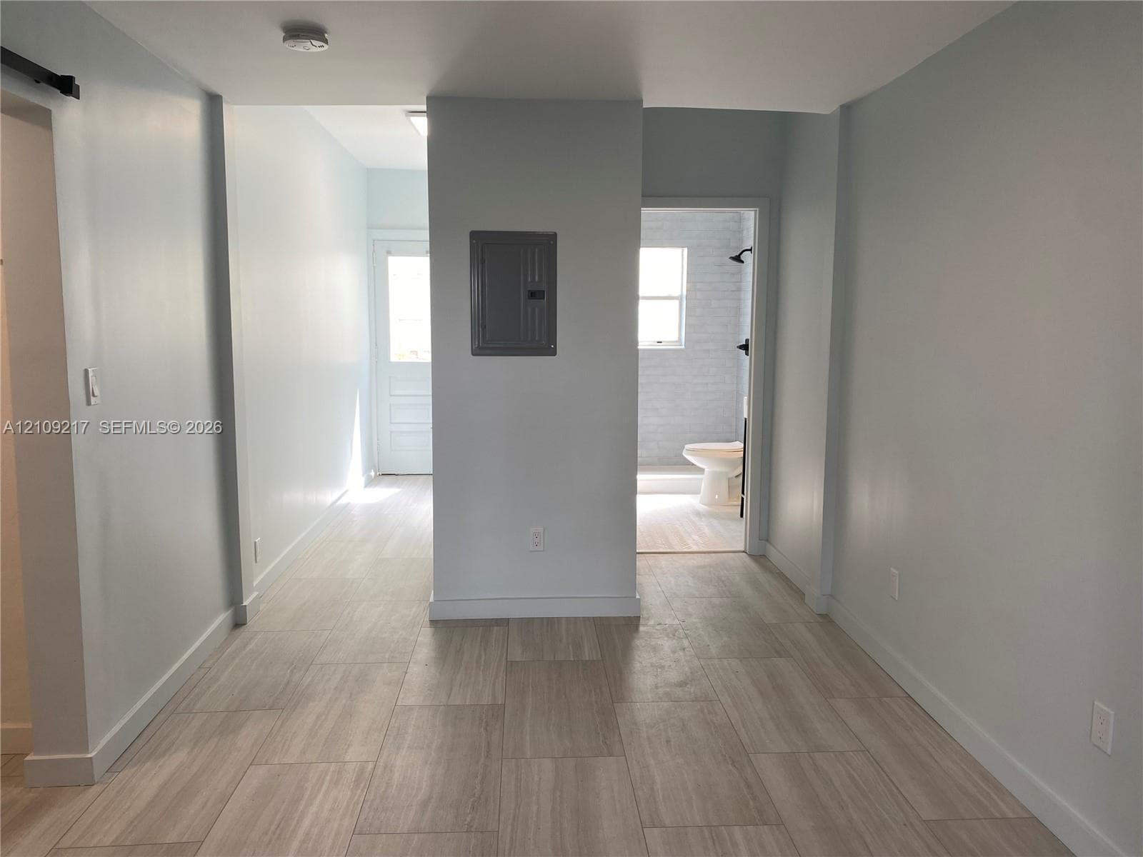 Neutral-toned tile flooring, recessed ceiling lighting, and a multi-lite glass panel exterior door