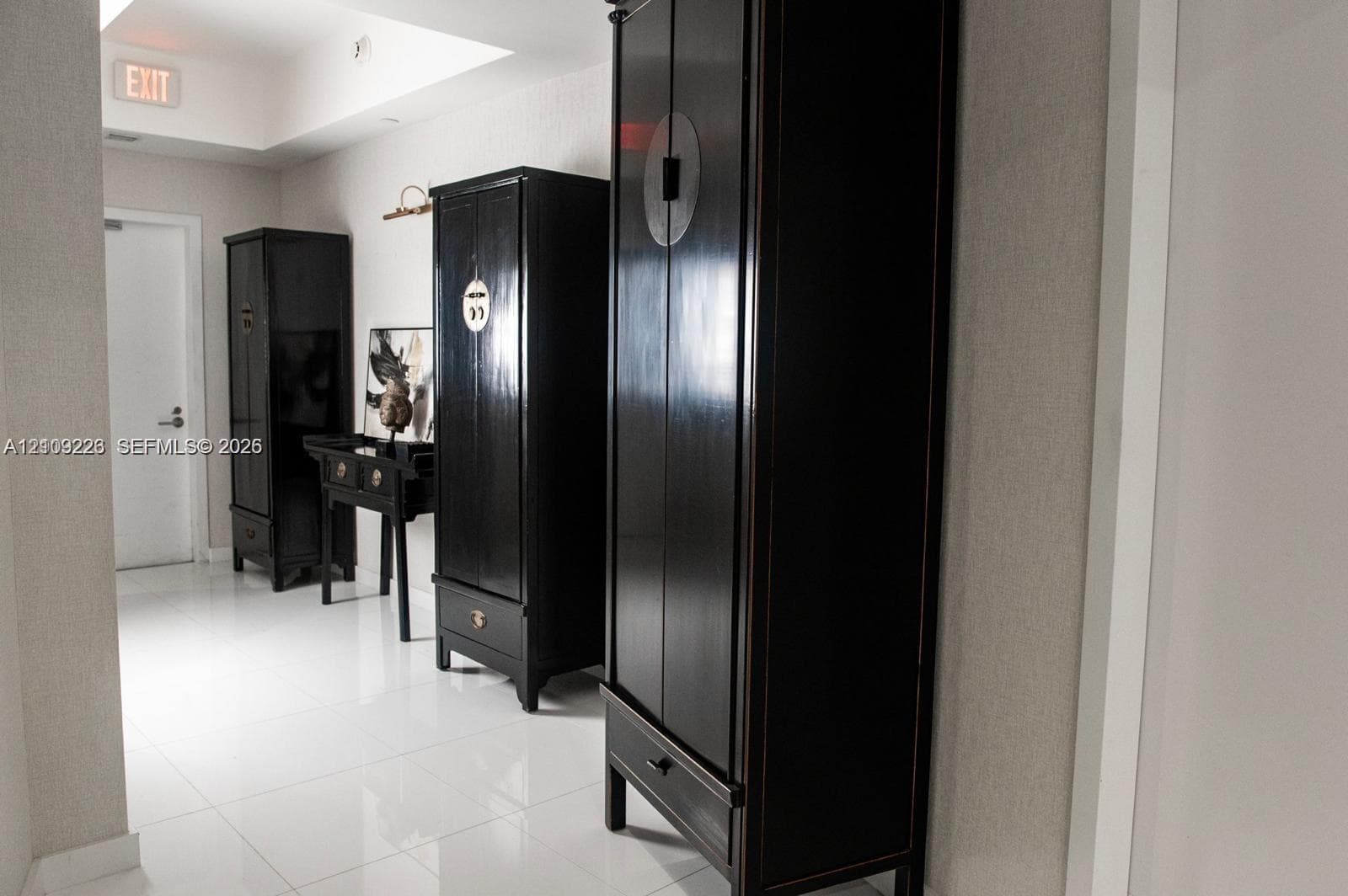 Polished white tile flooring, recessed ceiling lighting, and neutral wall tones
