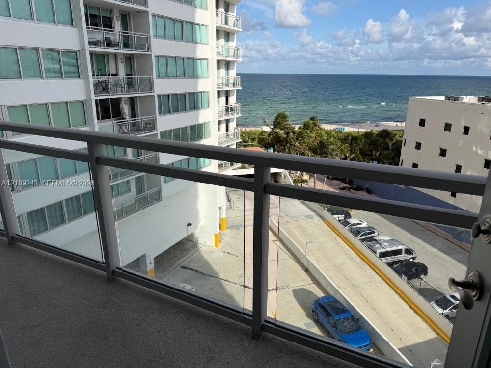 Private balcony featuring a glass panel railing and ocean scenery