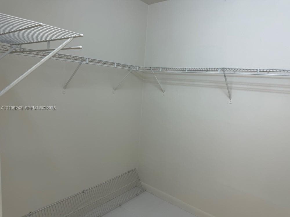 Storage area featuring white coated wire shelving units and integrated clothing rods