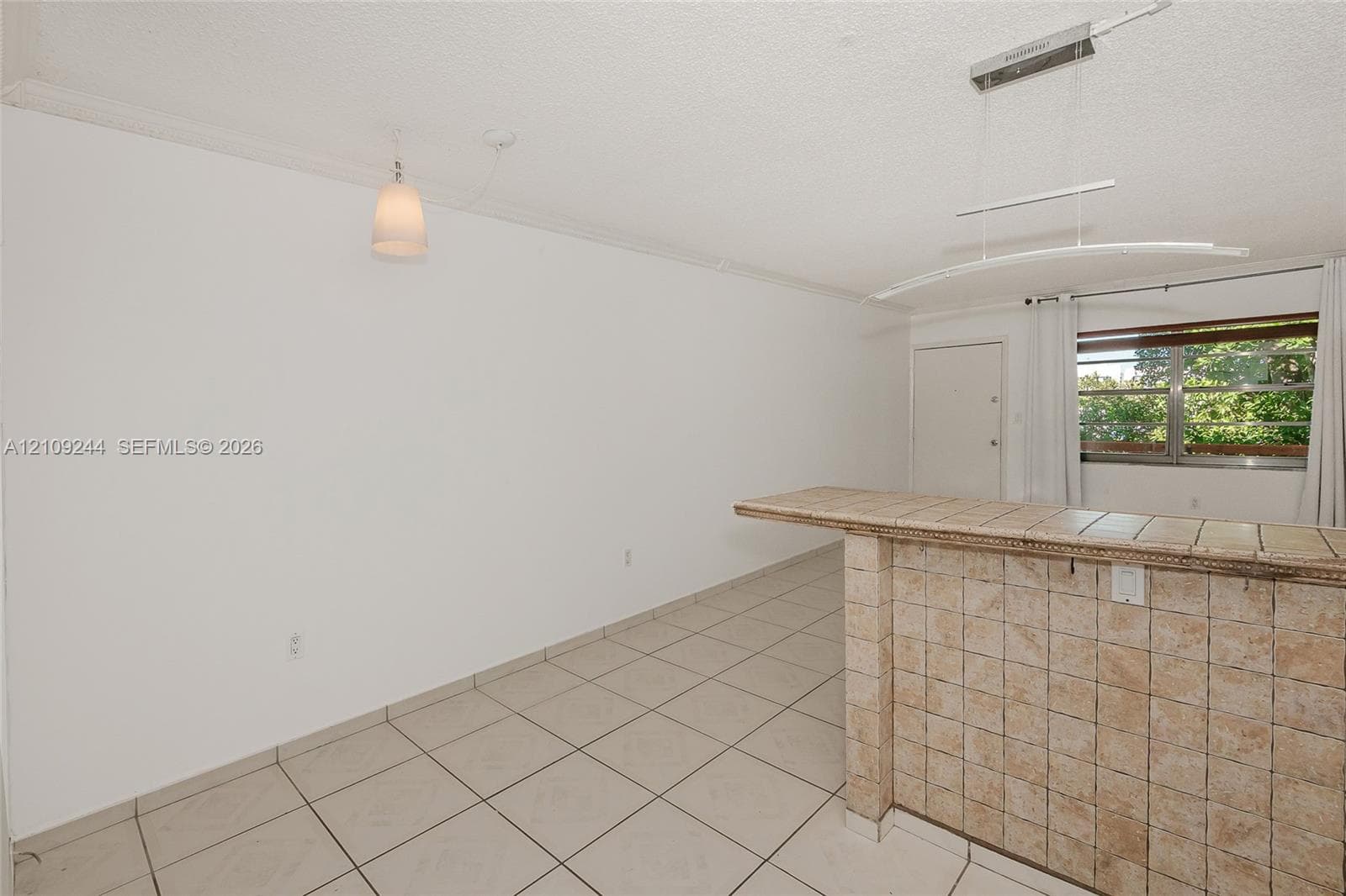 Ceramic tile flooring, built-in tiled breakfast bar, contemporary pendant lighting, and horizontal sliding windows