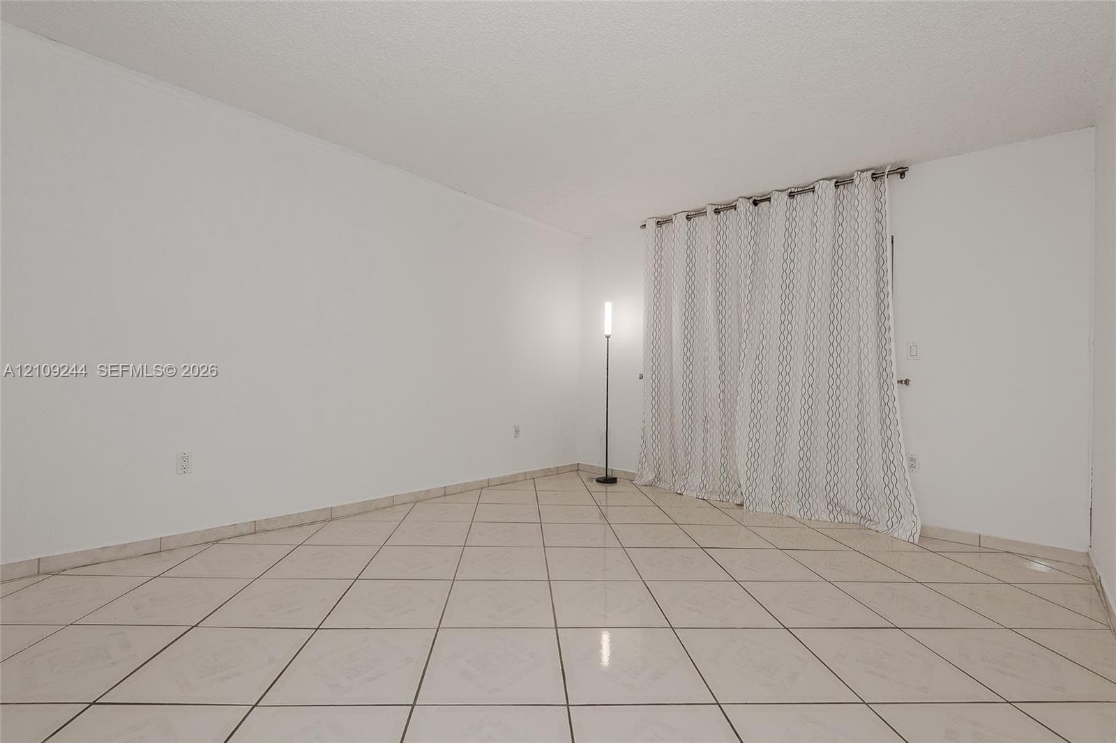 Room featuring neutral wall finishes and large-format ceramic tile flooring installed in a diagonal pattern