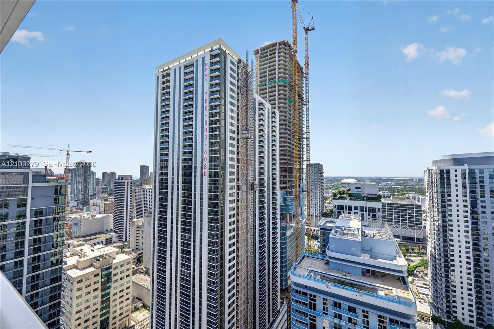 High-rise urban architecture featuring floor-to-ceiling glass paneling, recessed balconies, concrete structural elements, and a multi-level facade