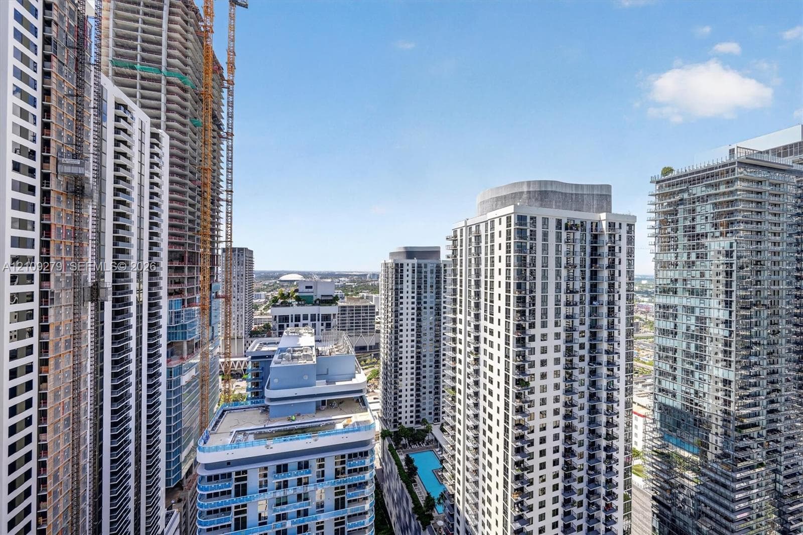 High-rise urban landscape featuring glass-facade residential towers, private balconies, and an outdoor swimming pool
