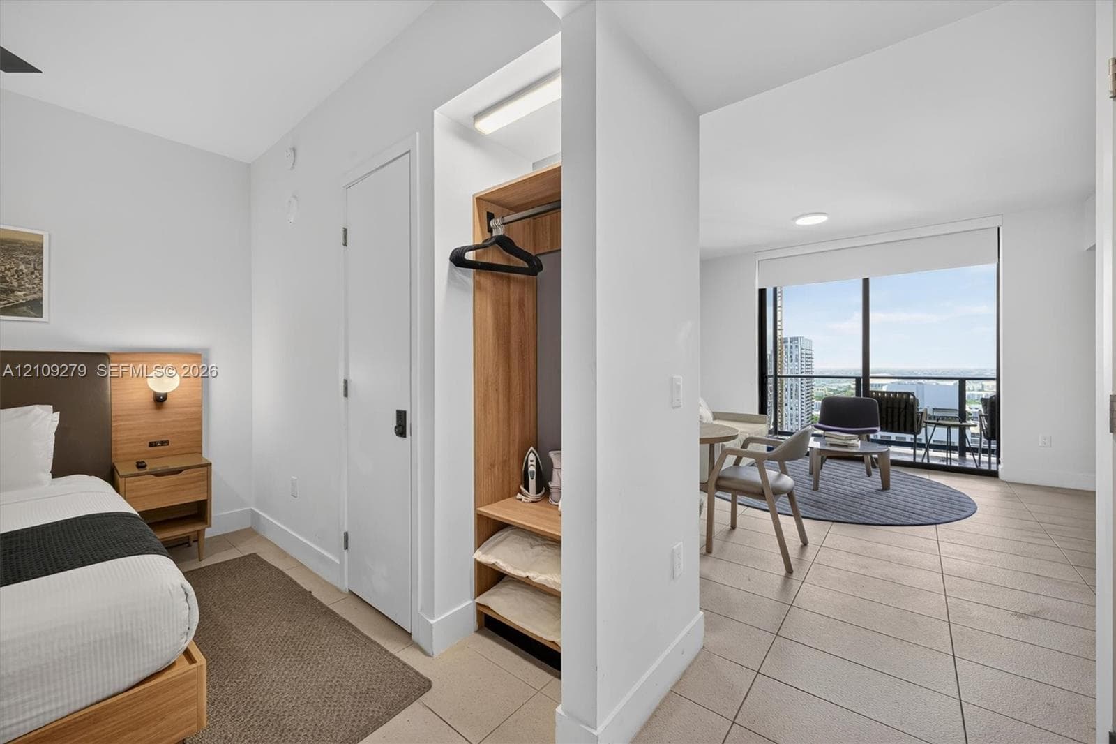 Floor-to-ceiling windows with urban skyline exposure, tile flooring, and built-in closet shelving