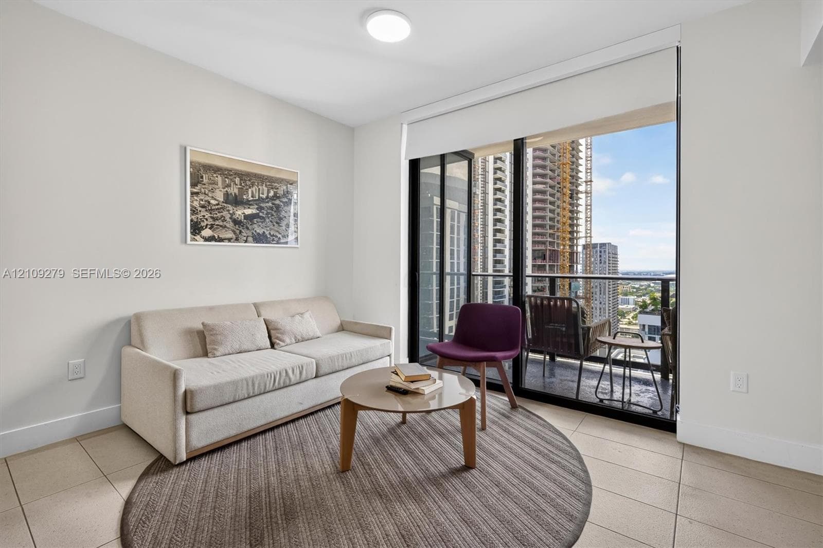 Floor-to-ceiling glass sliding doors, ceramic tile flooring, and private balcony with metal railing