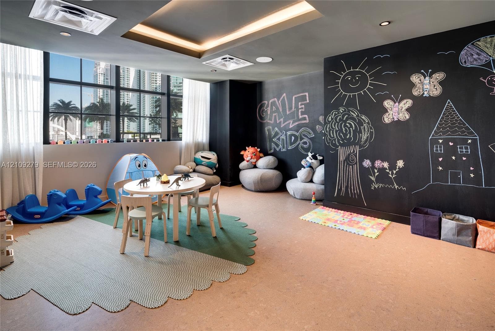 Interior space featuring large paneled windows, a dedicated chalkboard wall, recessed ceiling lighting, and smooth-finish flooring
