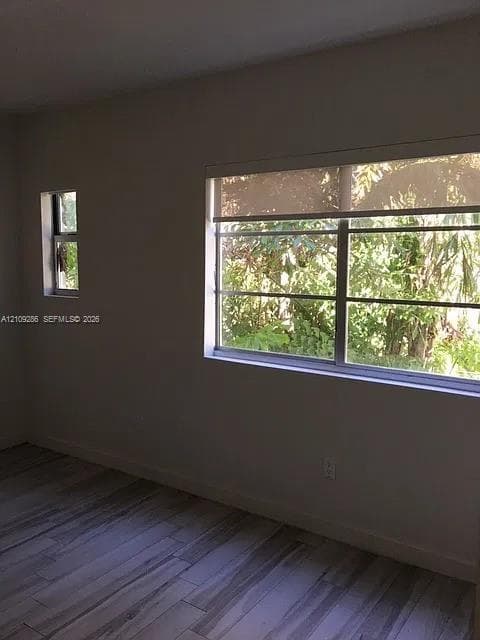 Neutral wall finishes, wood-finish flooring, and horizontal sliding windows providing natural light