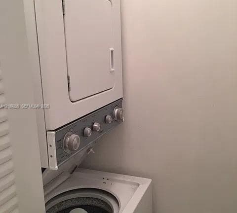 Stacked white laundry unit featuring a top-loading washer, front-loading dryer, and tactile control knobs