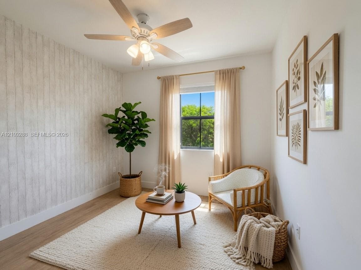 Room featuring wood-finish flooring, a textured vertical-plank accent wall, and a multi-blade ceiling fan with integrated lighting