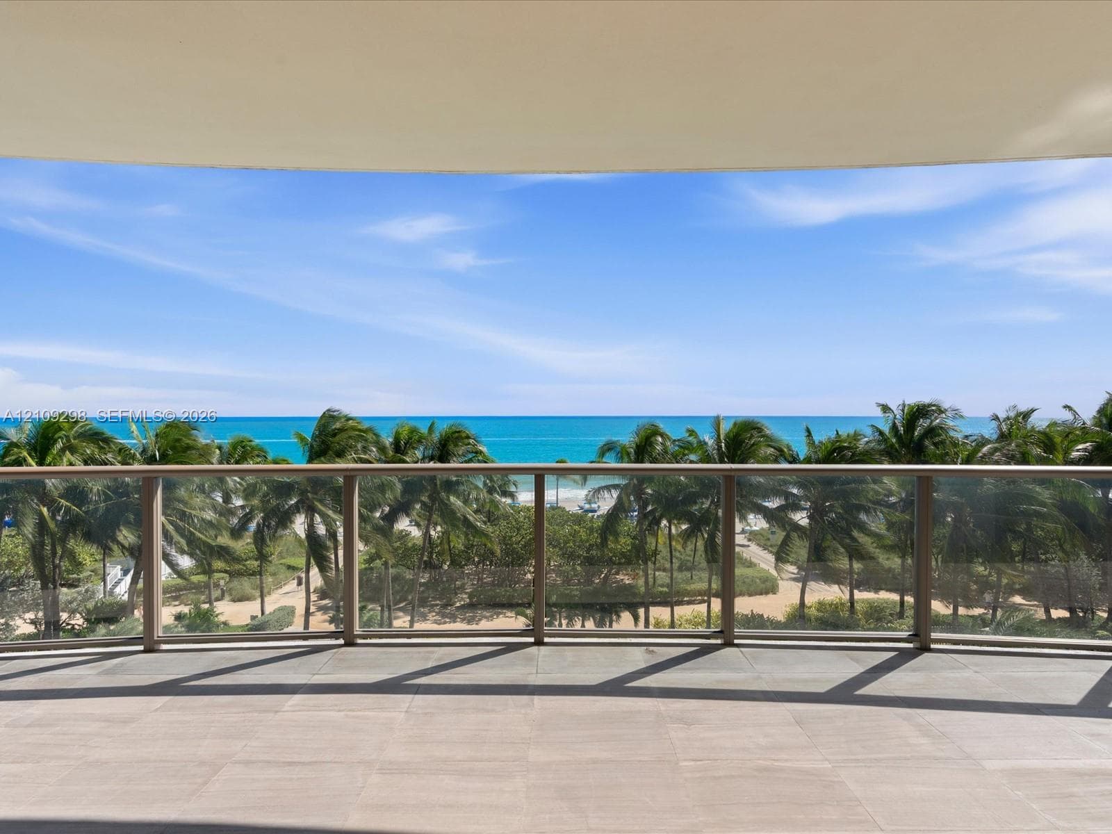 Twin high-rise towers featuring glass-paneled balconies, floor-to-ceiling windows, and manicured landscaping with mature palms