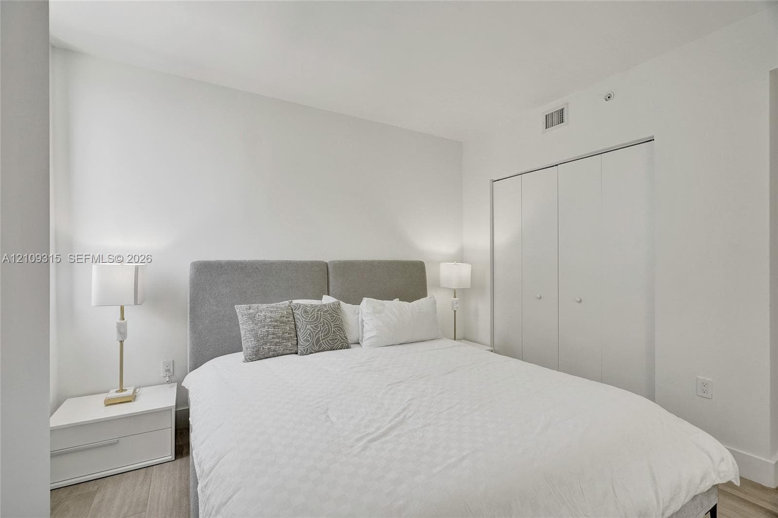 Neutral interior with wood-finish flooring and bi-fold closet doors